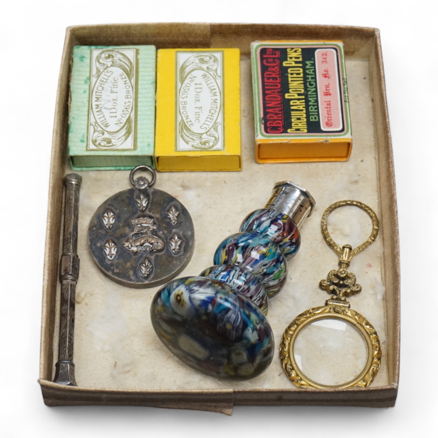 A small collection of objects to include a 17th century? French multi-cane glass seal, miniature white metal mirror and boxed pen nibs, seal 8cm high